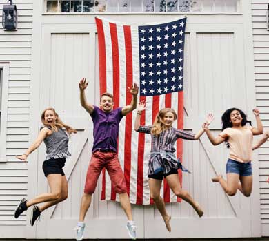 Counselor jumping in front of an American flag