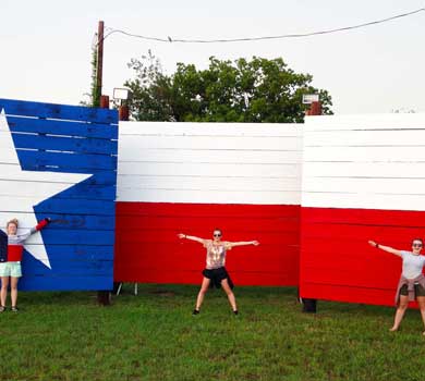 Counselors posing in front of Texas flag