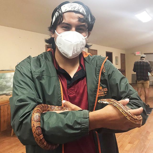 Counselor wearing a mask and holding a snake